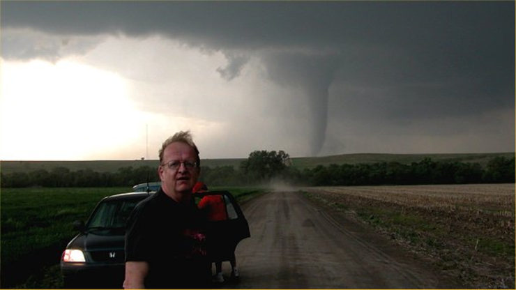 Ken Dewey stands near a tornado.
