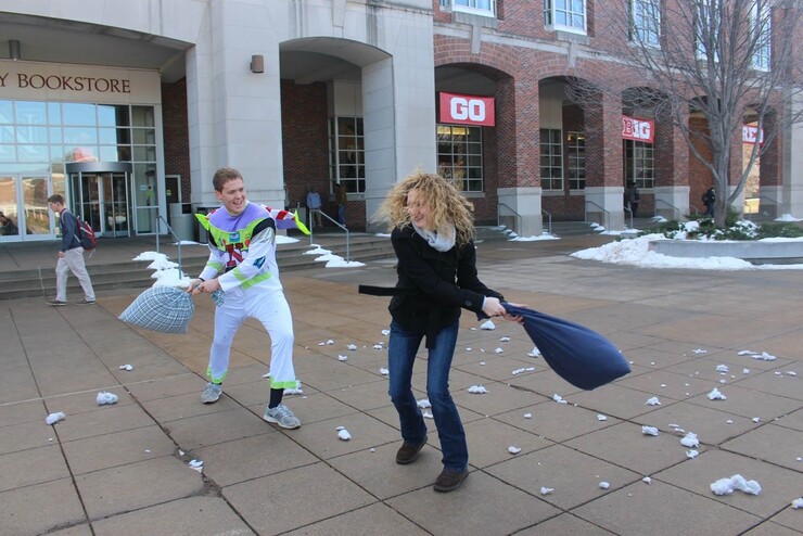 Brock Rezny hits UNL graduate student and UNL SMILE member Becca Hurst with a pillow during the organization’s finals week pillow fight. 