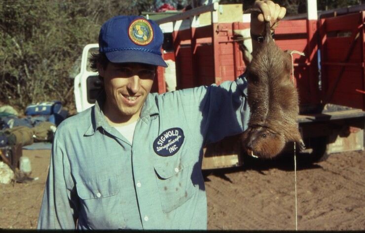 Scott Gardner holding a rodent in Bolivia