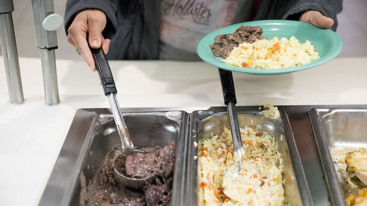 A UNL student dishes up some Brazilian feijoada (a stew of black beans and six meats) and rice in the Selleck Hall dining facility on Nov. 16. Selleck Hall has added a variety of international recipes to its regular menu through the years, most of which were requested by students.