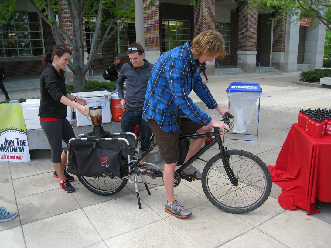 A person rides a bike that powers a blender that makes a smoothie during a past year's Bike Fest