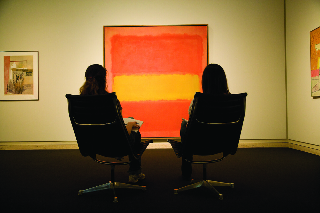 Two young women examine Mark Rothko's painting, "The Yellow Band," in the Sheldon Museum of Art.