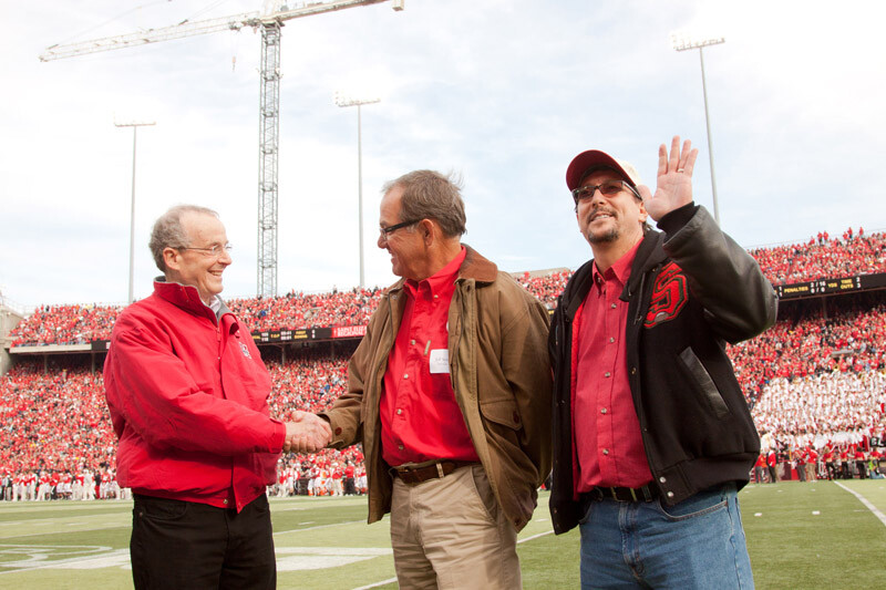 Chancellor Harvey Perlman shakes hands with Jeff Sotzing as Larry Witzer waves to the crowd during a second quarter time out at the Nov. 5 Husker football game. Sotzing and Witzer are with the John W. Carson Foundation. Photo by Craig Chandler|UComm