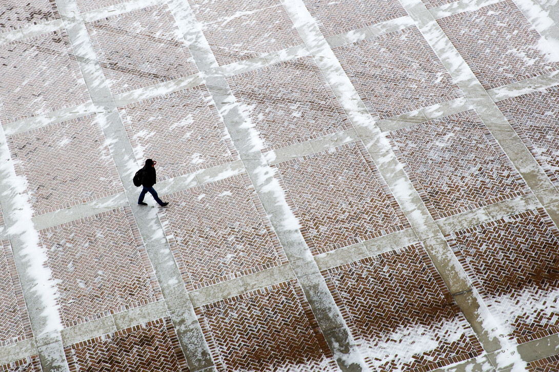 A UNL student walks through a snowy plaza on the east side of Memorial Stadium on Feb. 25. Al Dutcher, the state climatologist, said the winter was the 18th driest since 1896.
