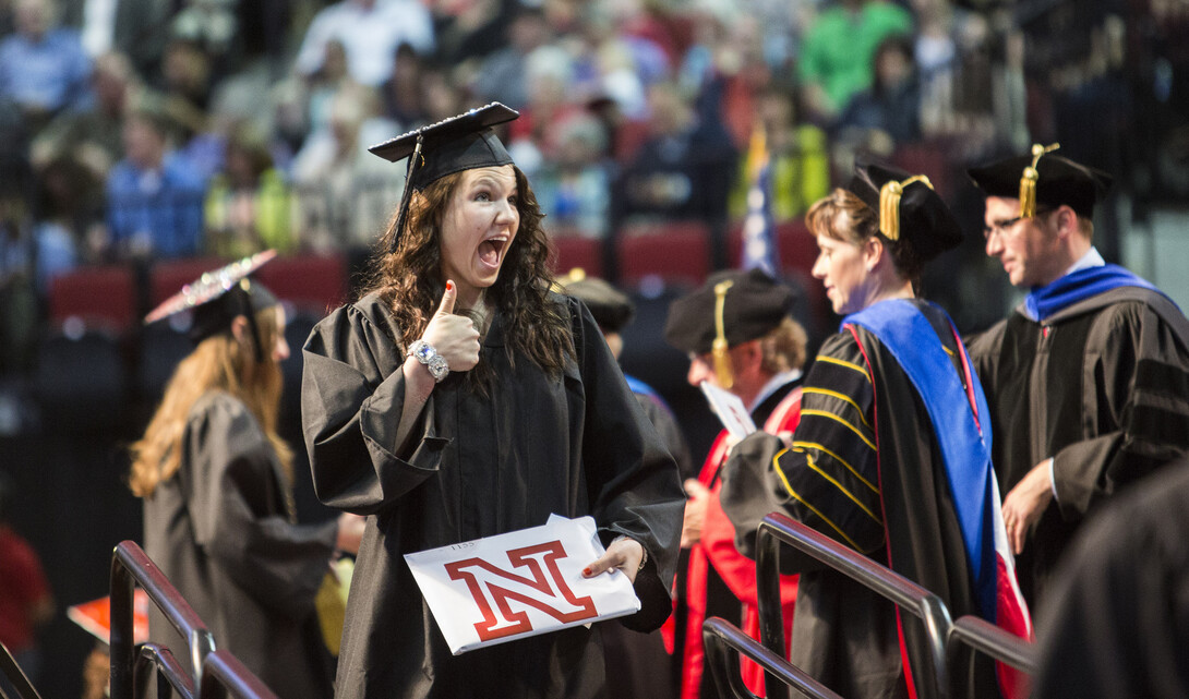 Sara Santin gestures to family and friends after receiving her diploma. 