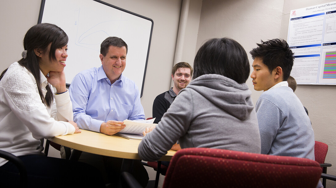 Eric Thompson (second from left), associate professor of economics and head of the Bureau of Business Research, works with student research assistants.