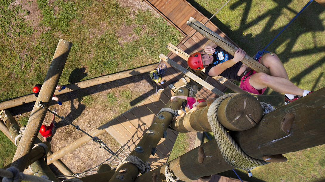 Cooper Knack climbs up a widely spaced wood and rope ladder on the Alpine Tower during the UNL Raikes School's Aug. 21 event at the Campus Recreation challenge course. The event included a variety of activities, including climbing a 50-foot-tall tower. 