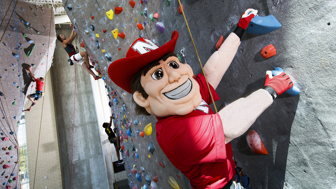 Herbie Husker scales the climbing wall in Nebraska's Outdoor Adventures Center.