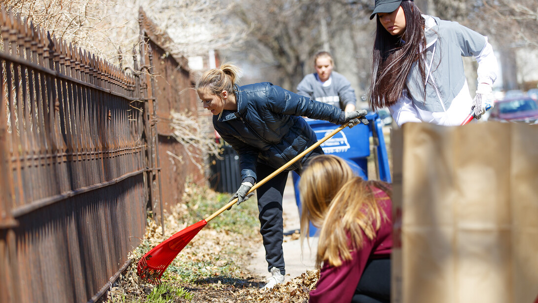 Huskers rake help rake leaves in a Lincoln neighborhood during the 2018 Big Event.