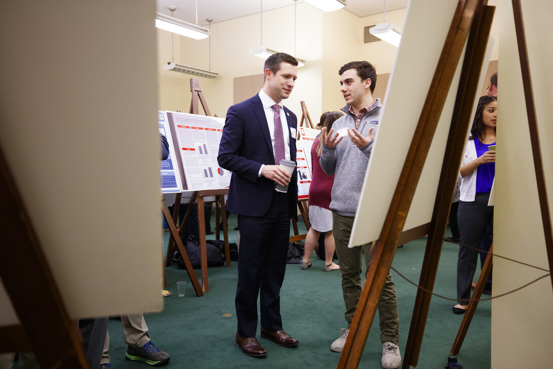 Sen. Adam Morfeld listens as Michael True discusses his research, "Species Richness, Relative Abundance, and Disease Exposure in Small Mammals."