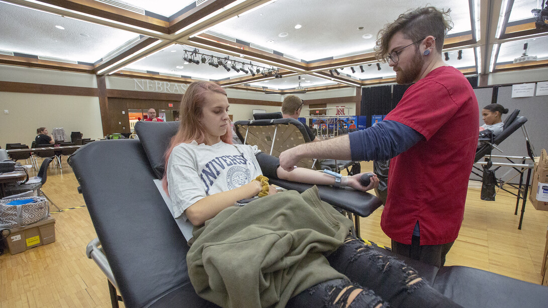 Nebraska's Anna Drelicharz watches as Logan Grimm of the American Red Cross adjusts a needle during the homecoming blood drive on Sept. 25. The donation was Drelicharz's first.
