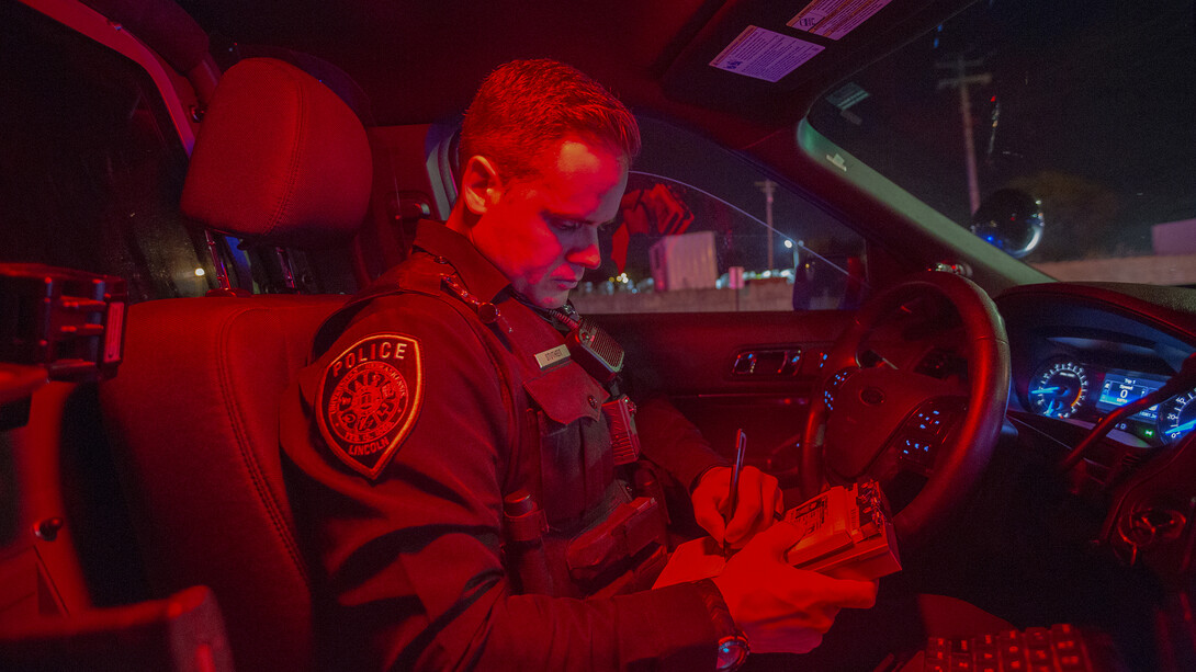 Officer Chadd Stutheit of the University Police Department writes a warning ticket during a traffic stop on Oct. 19.