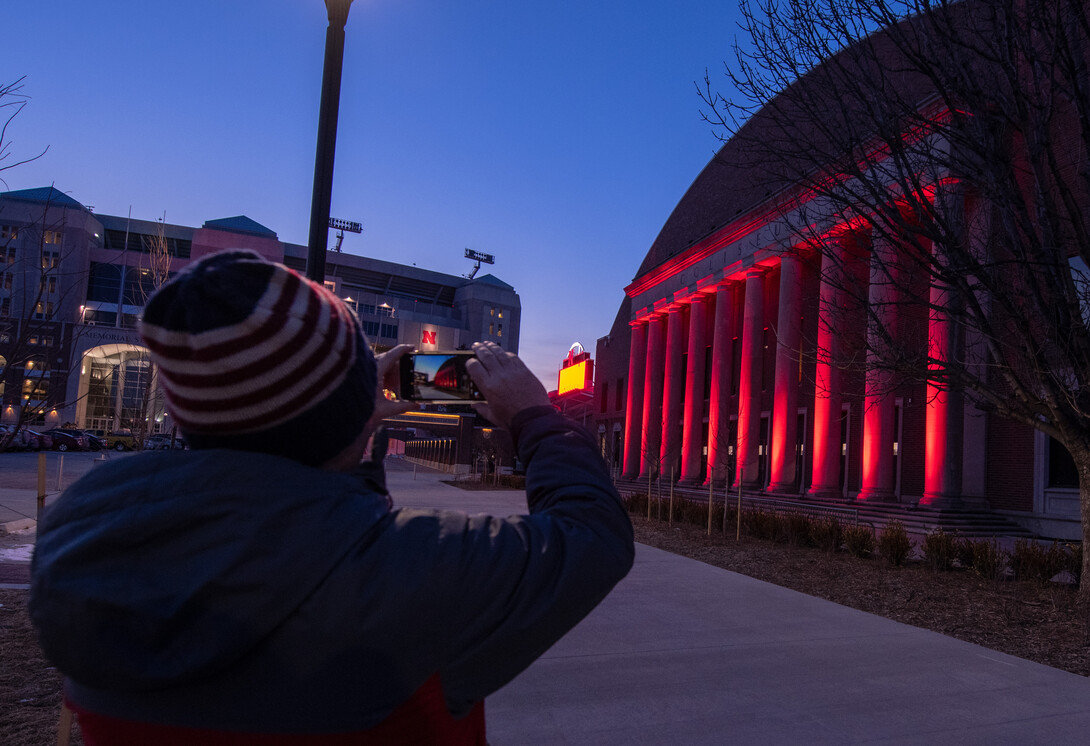 A student pauses to shoot a photo of the Coliseum during the Feb. 14 Glow Big Red event.