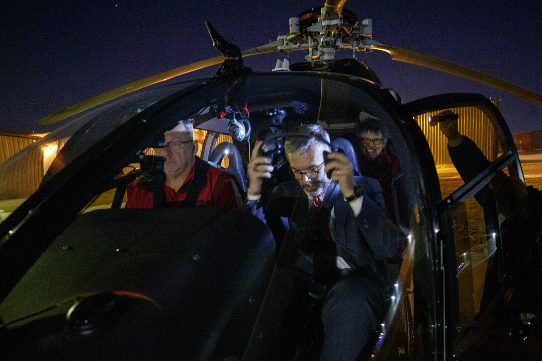 Chancellor Ronnie Green (right) boards a helicopter for a night flight over campus during the Glow Big Red event on Feb. 14.