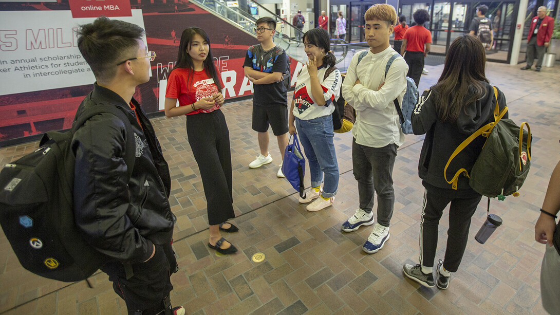 Nebraska's Bosi Fang (second from left) talks with students from China after they arrived in the Lincoln Airport on Aug. 16. Fang, a senior from Lincoln, uses her knowledge of Mandarin to talk with and answer questions from Chinese students.