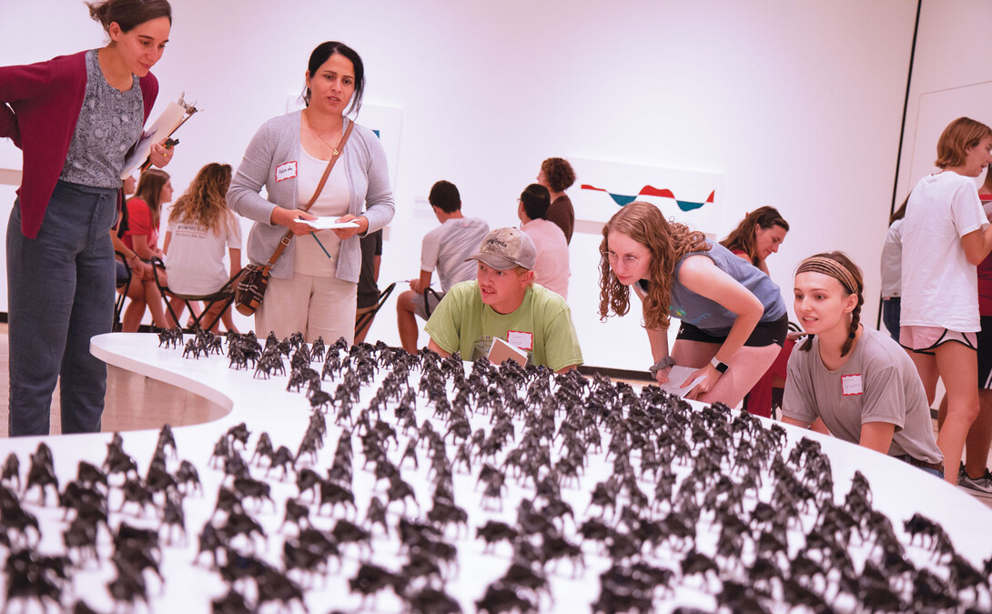 Student and Yazidi participants inspect part of the “Unquiet Harmony: The Subject of Displacement” exhibit at the Sheldon Museum of Art.