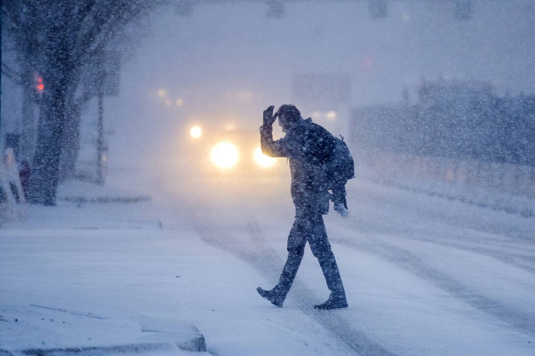 A person crosses a street during a Lincoln, Nebraska, blizzard in December 2019.