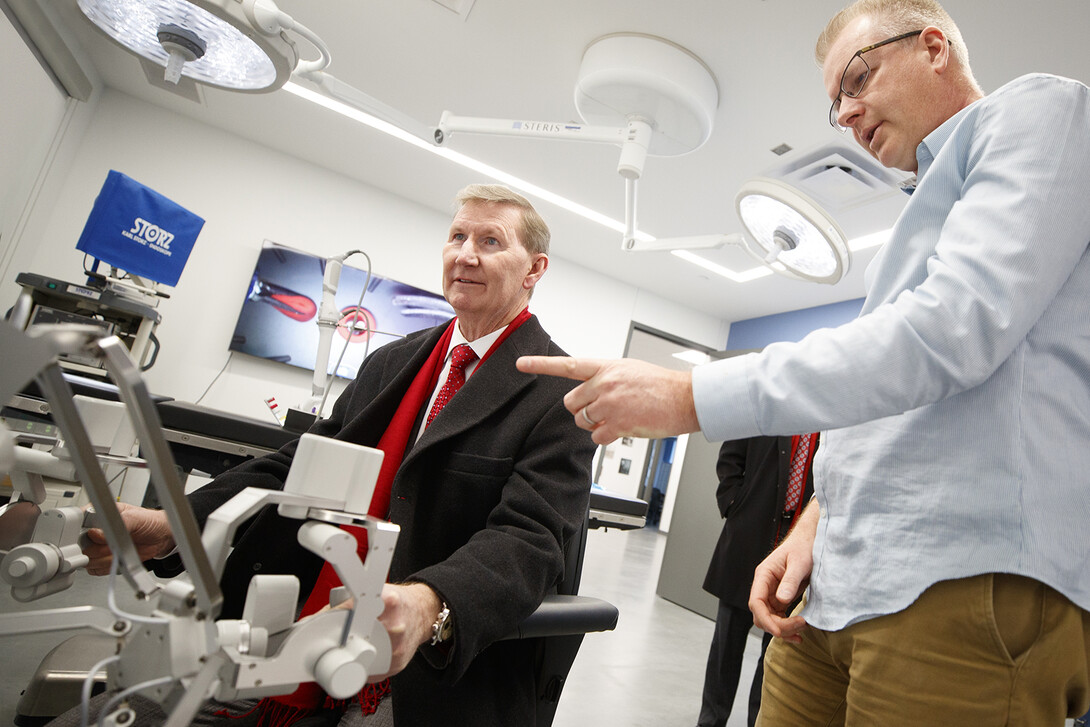 Shane Farritor (right), professor of mechanical and materials engineering, helps Ted Carter control a surgical robot in a Virtual Incision lab at Nebraska Innovation Campus. Carter’s two-day tour included stops at City, East and Nebraska Innovation campuses.