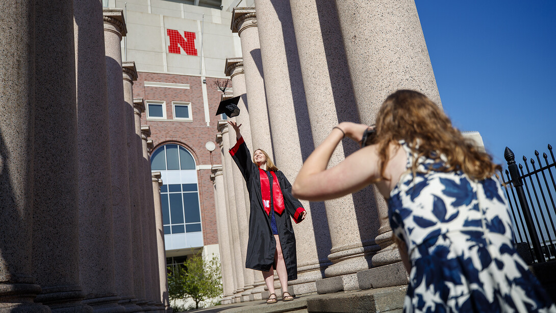 Rose Wehrman (in regalia) and Sarah Schilling prepared for commencement in spring 2020 by shooting photos amongst the Columns by Memorial Stadium. The iconic pillars, which have stood by Memorial Stadium for 86 years, will be on the move this summer as construction begins on the Huskers’ new athletics facility.