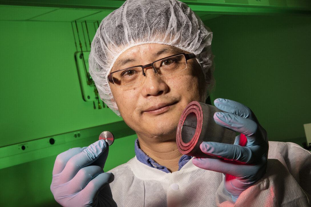 Shouyuan Chen, UNL research assistant professor of physics and astronomy, shows a uranium disk and steel casing. An X-ray laser successfully imaged the uranium hidden within the casing.