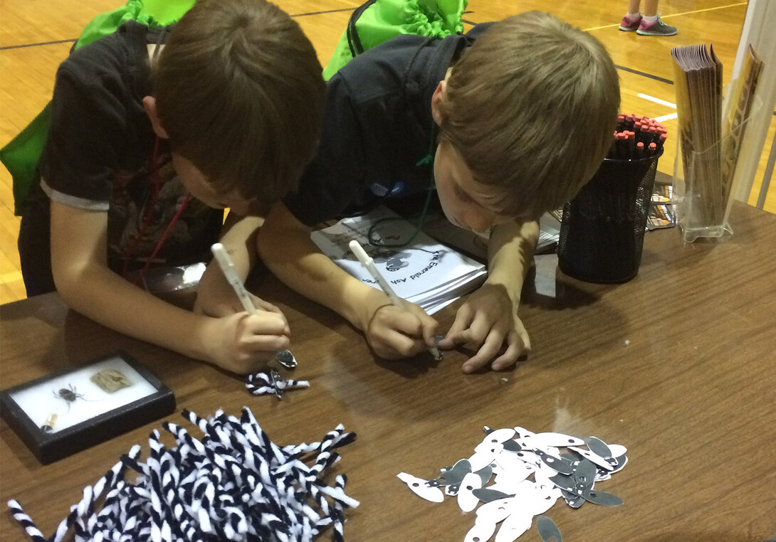 Two children work to build an Asian long-horned beetle as part of a community event with the Nebraska Invasive Species Program.