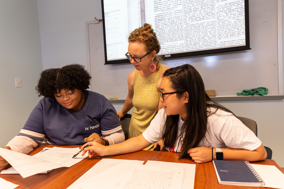 Katrina Jagodinsky, associate professor of history, advises two undergraduate researchers on a research project in the Center for Digital Research in the Humanities.
