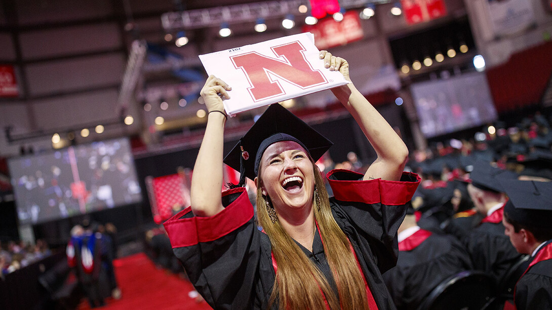 Hailey Lehms celebrates her newly earned Bachelor of Journalism as she returns to her seat during the morning undergraduate commencement ceremony May 4 at Pinnacle Bank Arena.