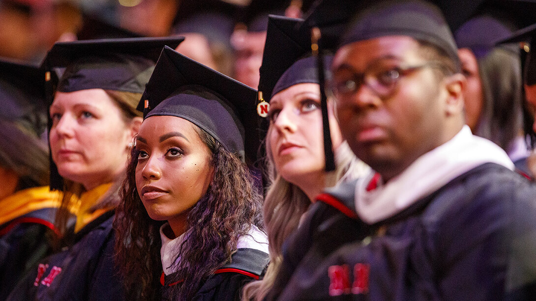 Briana Aldridge watches the greetings on the video screen at the start of the graduate and professional degree ceremony Dec. 20 at Pinnacle Bank Arena. Aldridge earned a Master of Arts.