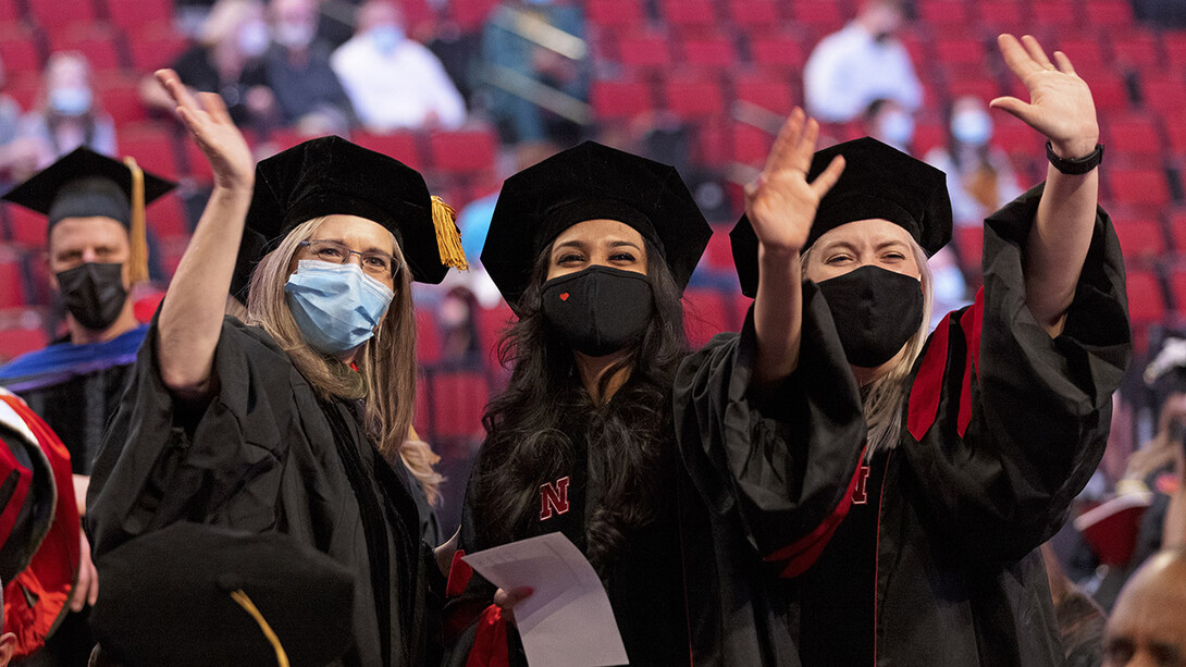 Stacie Ray (left), professor of practice in special education and communication disorders, and audiology doctoral students Manami Shah (center) and Emma Wilken wave to family and friends before the graduate and professional degree ceremony May 7 at Pinnacle Bank Arena.