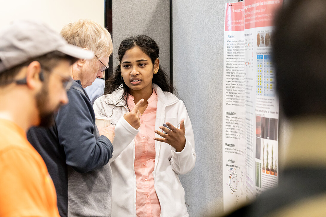 Plant Pathology graduate student Haritha Nunna discusses her presentation, Transgenic wheat harboring viral Nia-Protease gene confers resistance against wheat streak mosaic virus, with poster judge Dr. Kenneth Nickerson, Emeritus Professor, School of Biological Sciences at the 2022 UNL Microbiology Research Symposium.