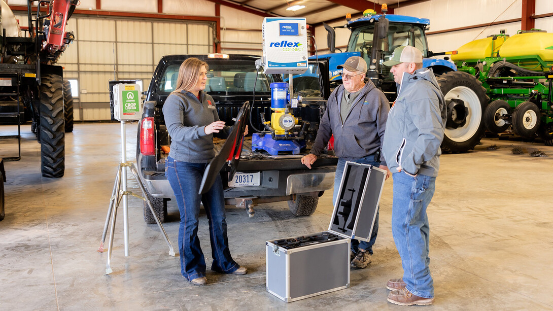 Taylor Cross (left), a graduate student in mechanized systems management, describes to Nebraska ag producers Doug Jones (center) and Tony Jones how drones use multrispectral imagery to detect nitrogen levels that enable precise nitrogen application.