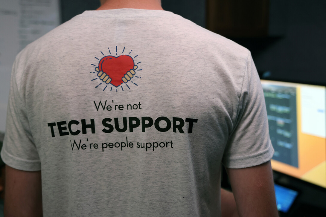 A 1to1 Technologies’ employee wears a shirt with the company’s tagline, "We're not tech support; we're people support," on the back.