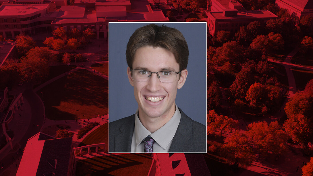 Color photo of Brian Beach on a red campus background