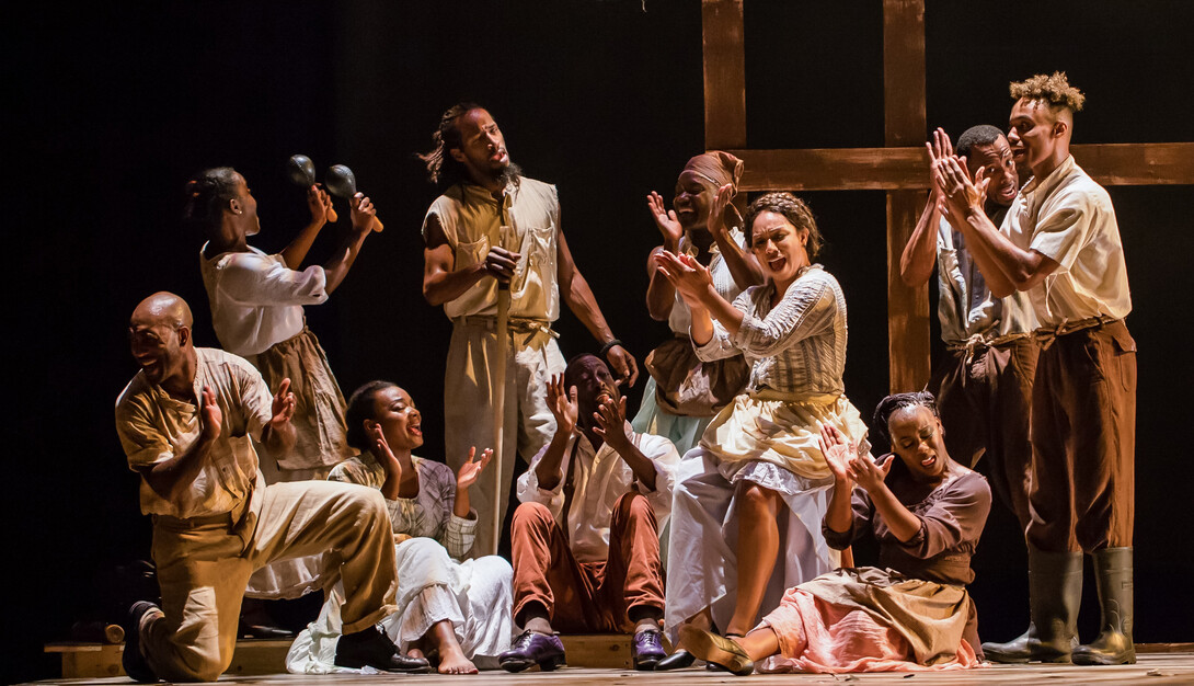 Ten members of Step Afrika! clap and sing onstage.