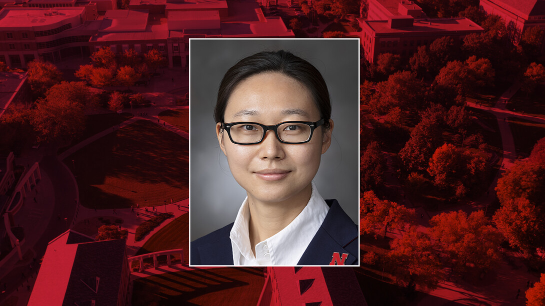 Color portrait of Shuai Nie on a red campus background