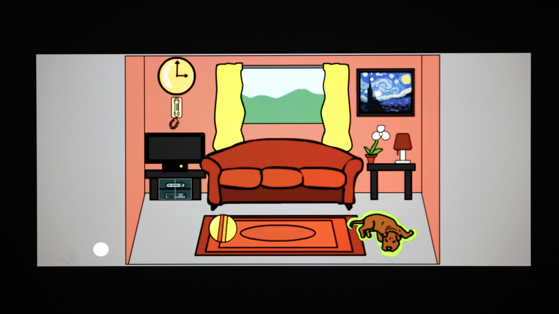 A computer screen shows a drawing of a living room, with a sofa, window, television, clock, phone, painting, side table, flower, lamp, rug and dog. The dog, on the lower right, is highlighted in yellow.