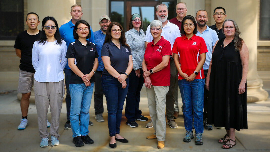 Outdoor group photo with seven men and seven women