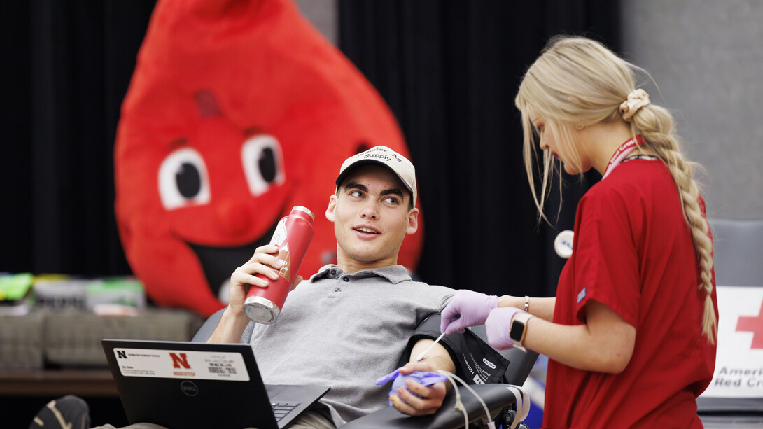 Under the watchful eyes of Buddy the Blood Drop, Caleb Preister, a senior biological systems engineering major from Lindsey, Nebraska, completes a donation during the University of Nebraska–Lincoln’s 2023 homecoming blood drive.