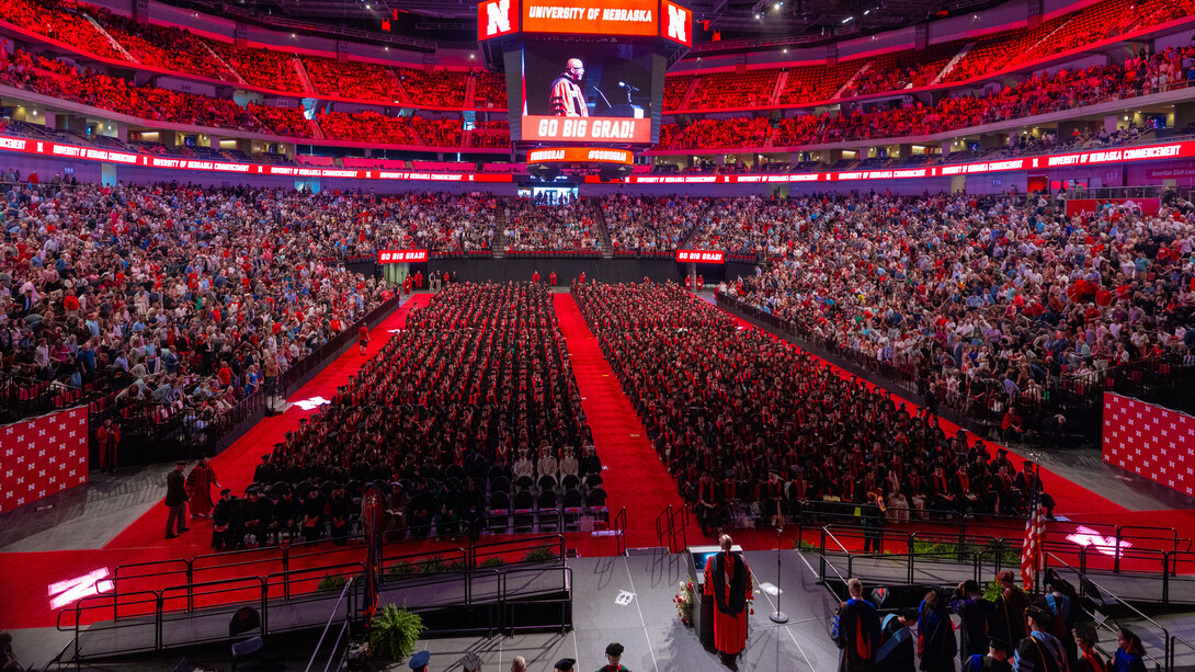Aerial photo of a nearly full Pinnacle Bank Arena during a May commencement ceremony. Chancellor Rodney D. Bennett can be seen speaking onstage.