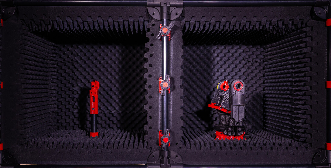 Two black foam-lined chambers with red-and-black equipment inside.
