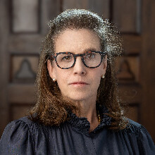 Color portrait of Julia Blaut in a dark, wood-paneled room.