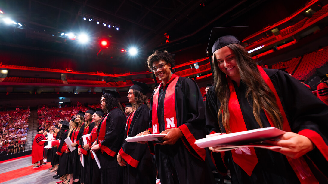 Graduates grin after receiving their diplomas during the combined graduate and undergraduate commencement ceremony Aug. 16 at Pinnacle Bank Arena.