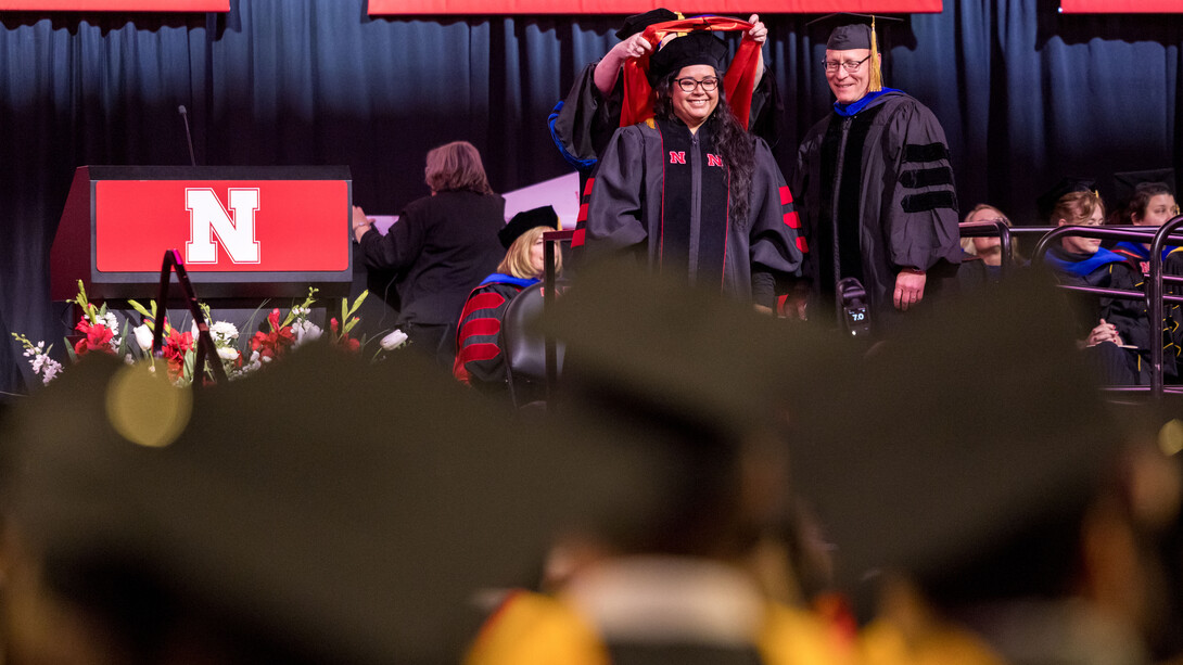 Jazmin Ley of Alamo, Texas, receives her doctoral hood on stage at Pinnacle Bank Arena during the graduate and professional degree ceremony Dec. 19 at Pinnacle Bank Arena.