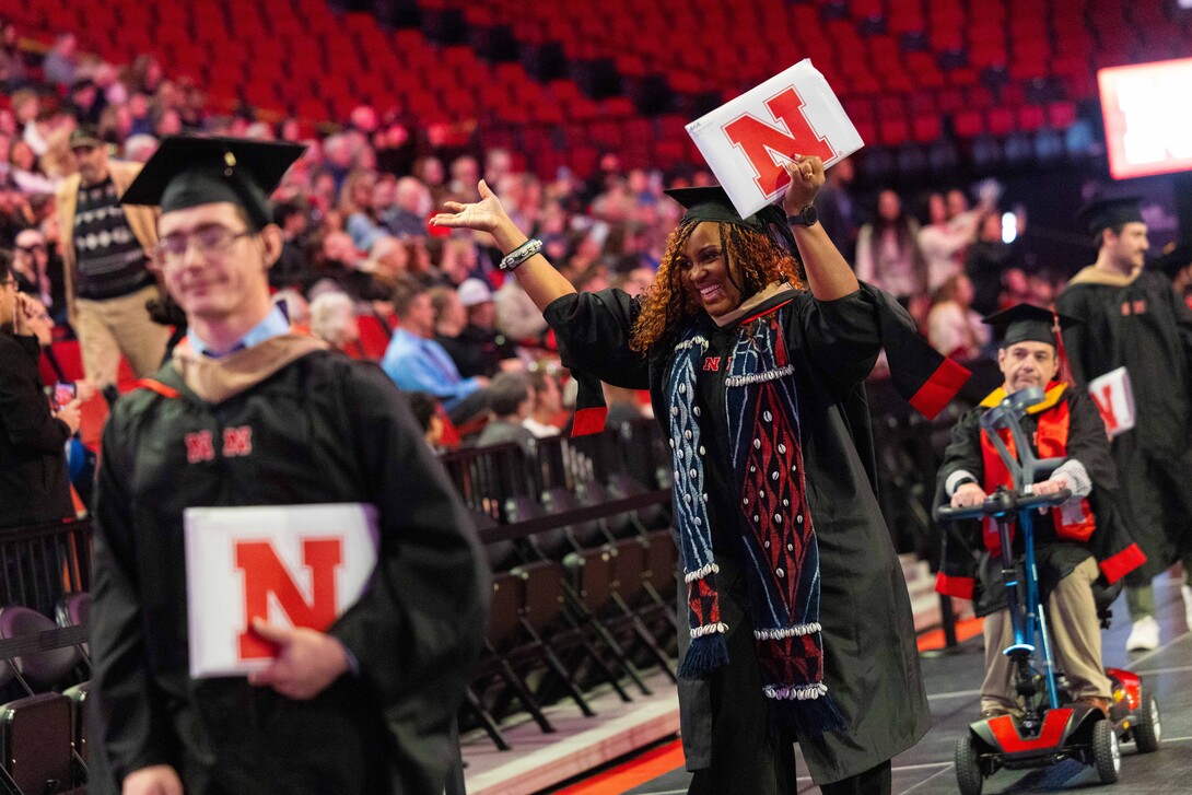 Marcelle Lisa Dongmo Takouzin of Lincoln puts her hands and diploma in the air in celebration during the recessional of the graduate and professional degree ceremony Dec. 19 at Pinnacle Bank Arena. She earned a Master of Professional Accountancy. (Liz McCue/University Communication and Marketing)