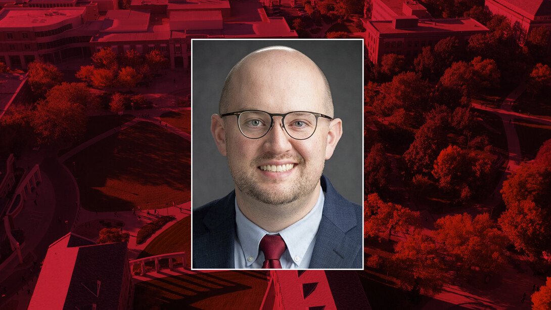 Color portrait of Zane Gernhart on a red campus background.