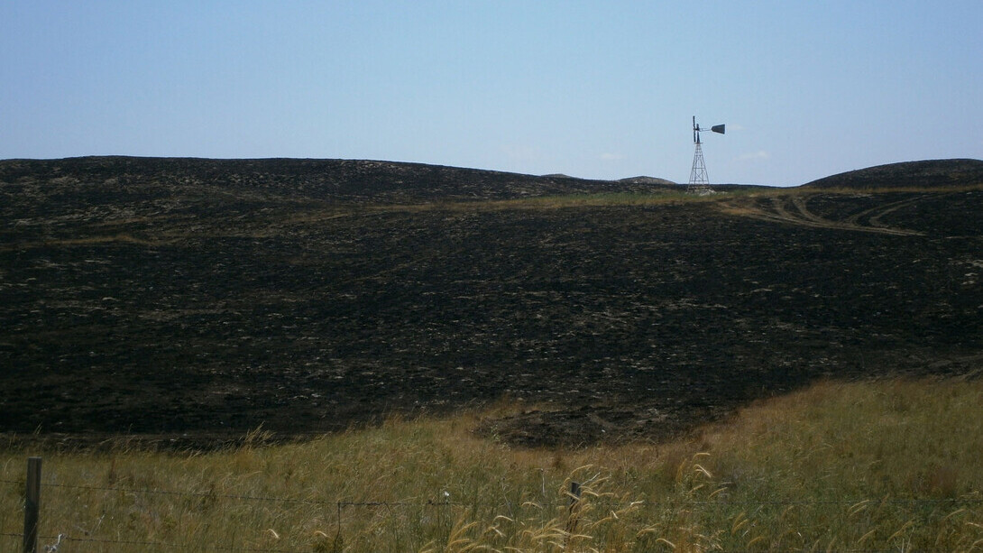 A windmill stands in a charred field in western Nebraska.