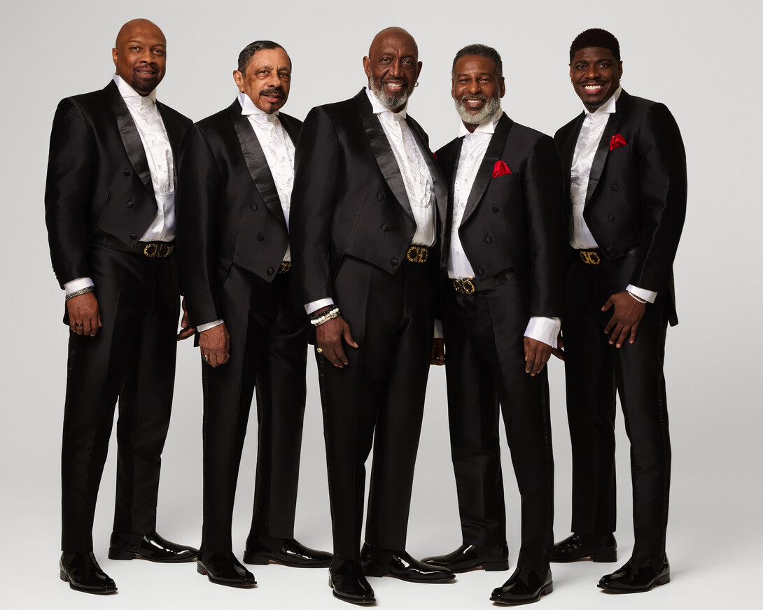 The Temptations — five men in matching black-and-white suits —&nbsp;pose for a group photo.