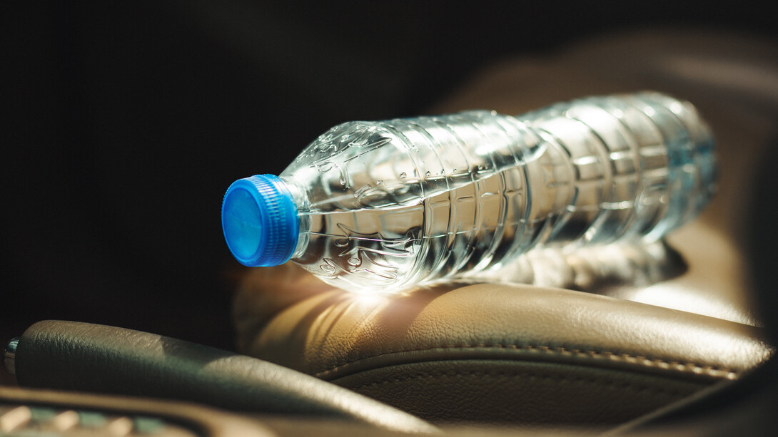 A water bottle sits on the sunny seat of a vehicle.