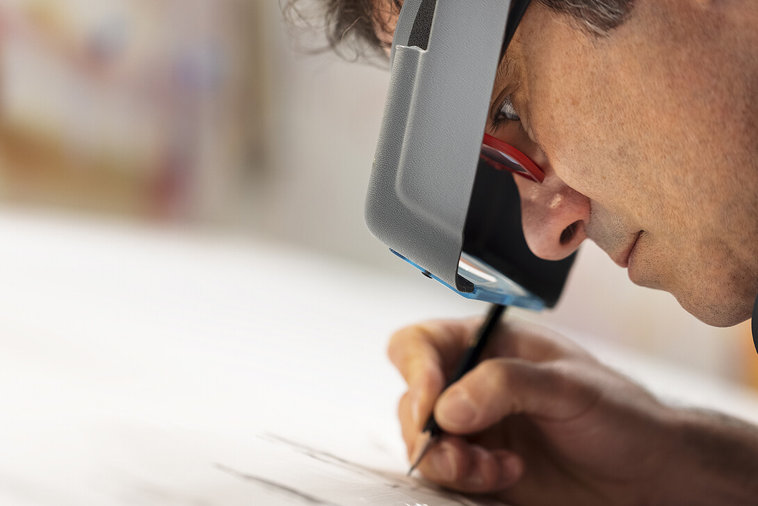 To create the intricate details in his drawings, Francisco Souto wears a visor that magnifies his work.