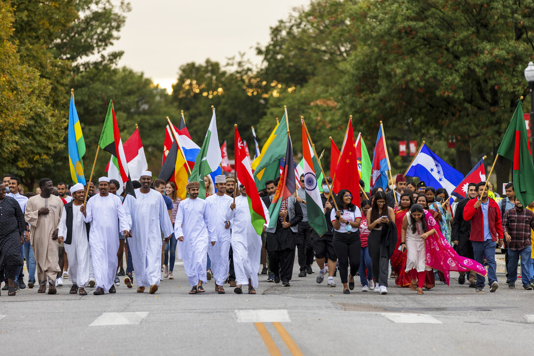 International students carry flags in the Homecoming parade